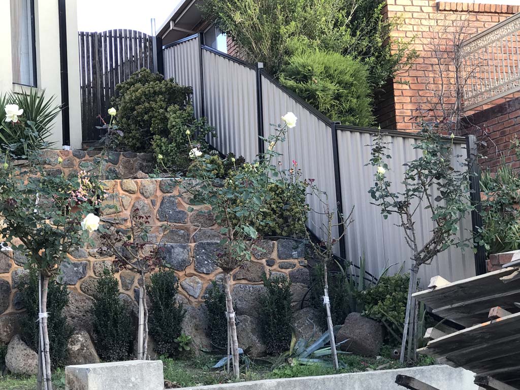 Colorbond fence sloping down the land